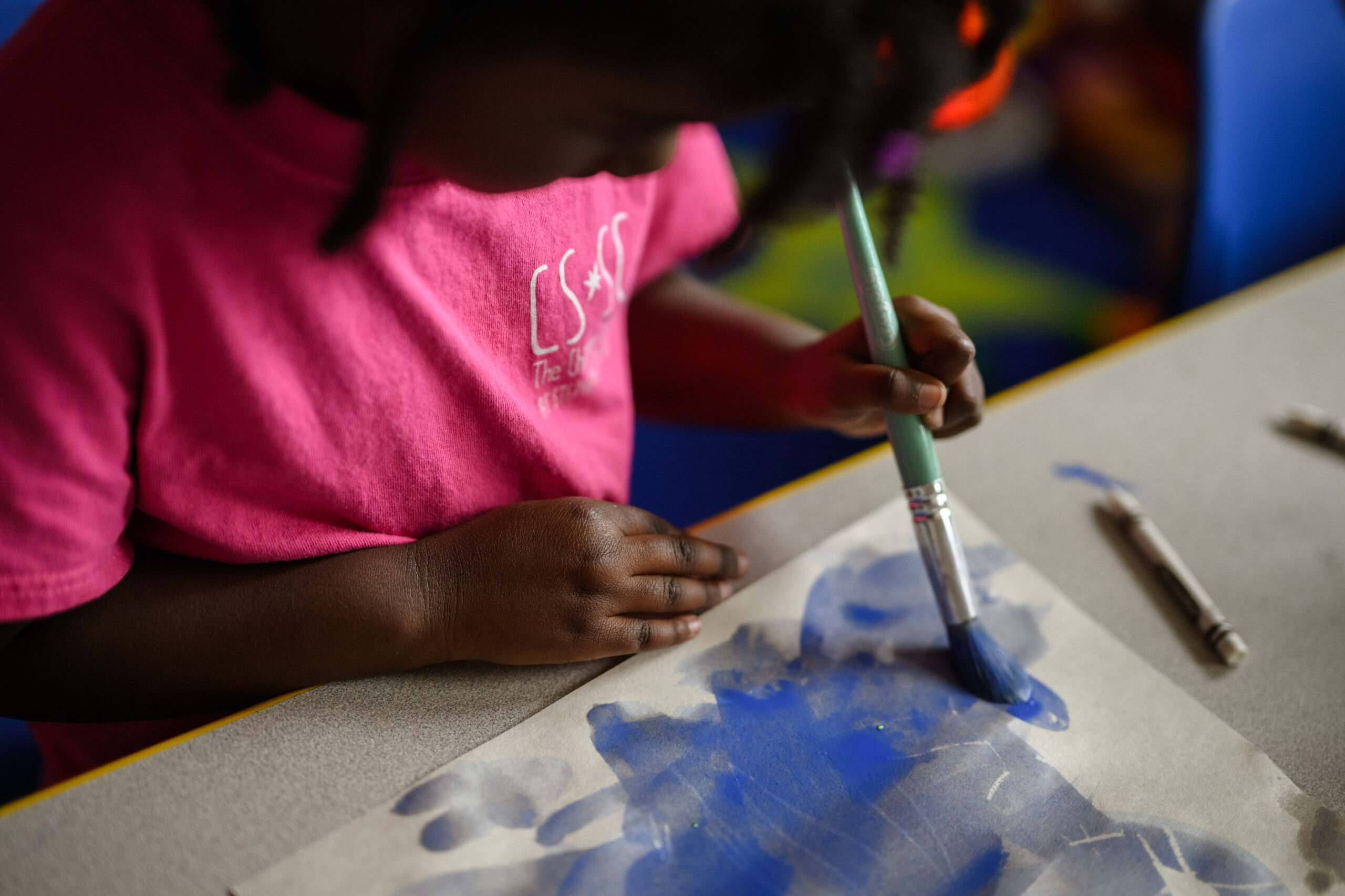 Child paints with watercolors at the Children's School at Stephens College.