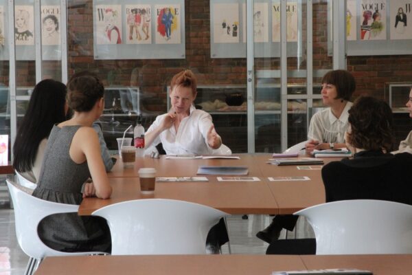 Amy Bond and several students engaged around a table.