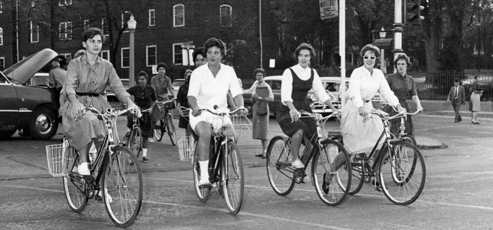 Black and white photo of a group of women riding bicycles in Columbia in the early 1960s.