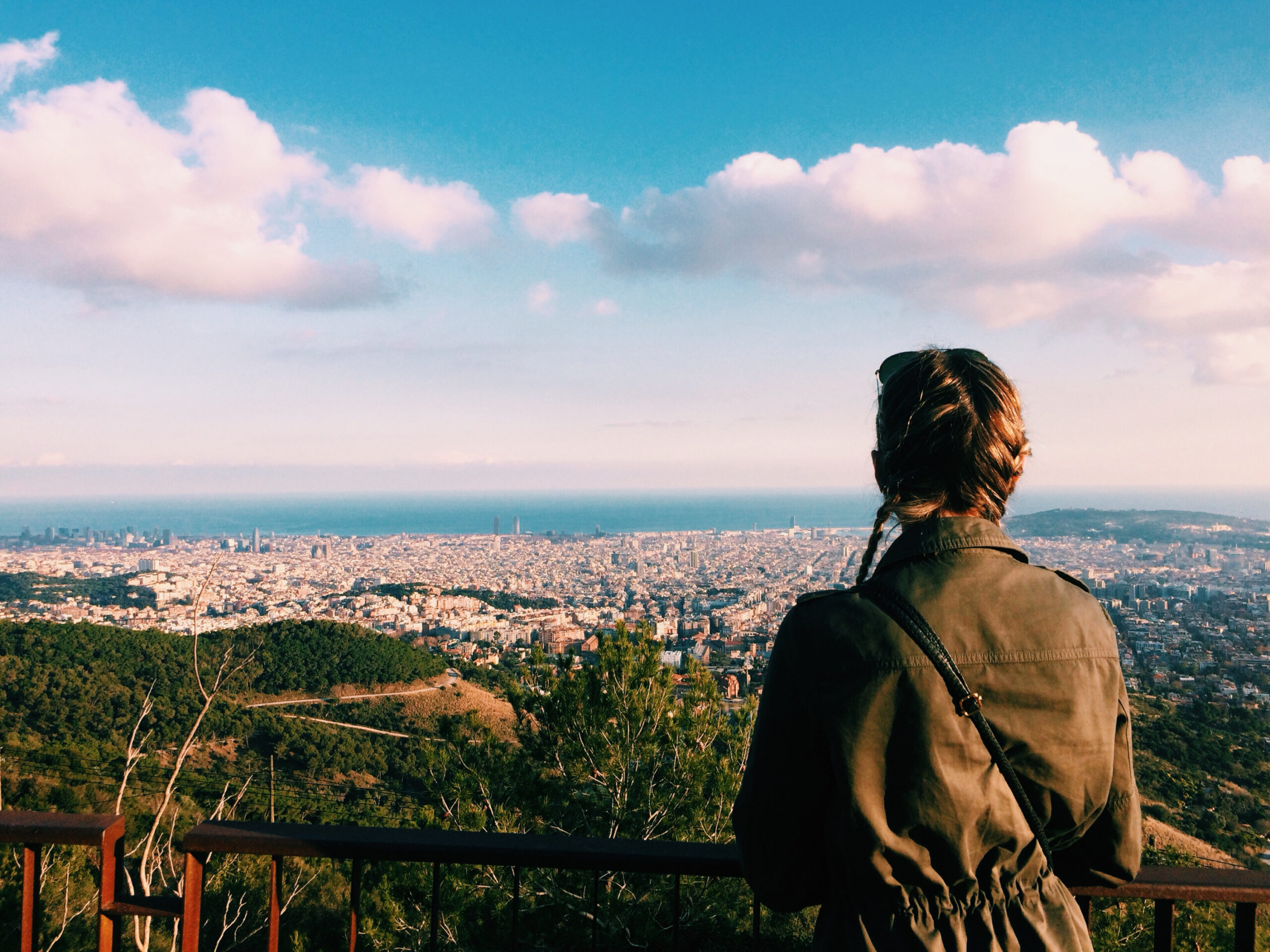 A young woman gazes down at the city of Columbia Missouri from an elevated spot on a hike.