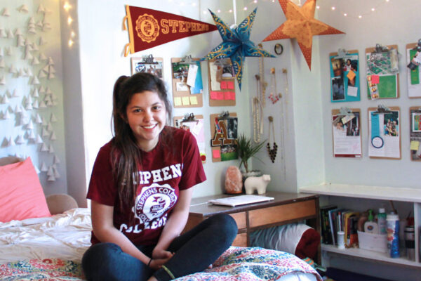 Stephens College student sitting on her bed in a fun dorm room