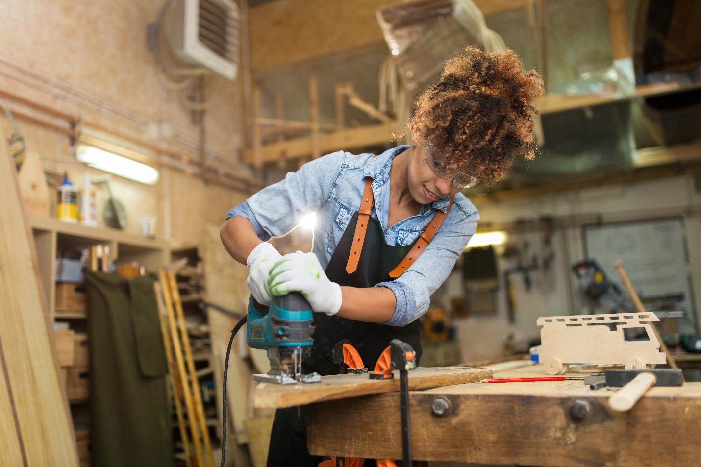 Woman operating a saw in a workshop