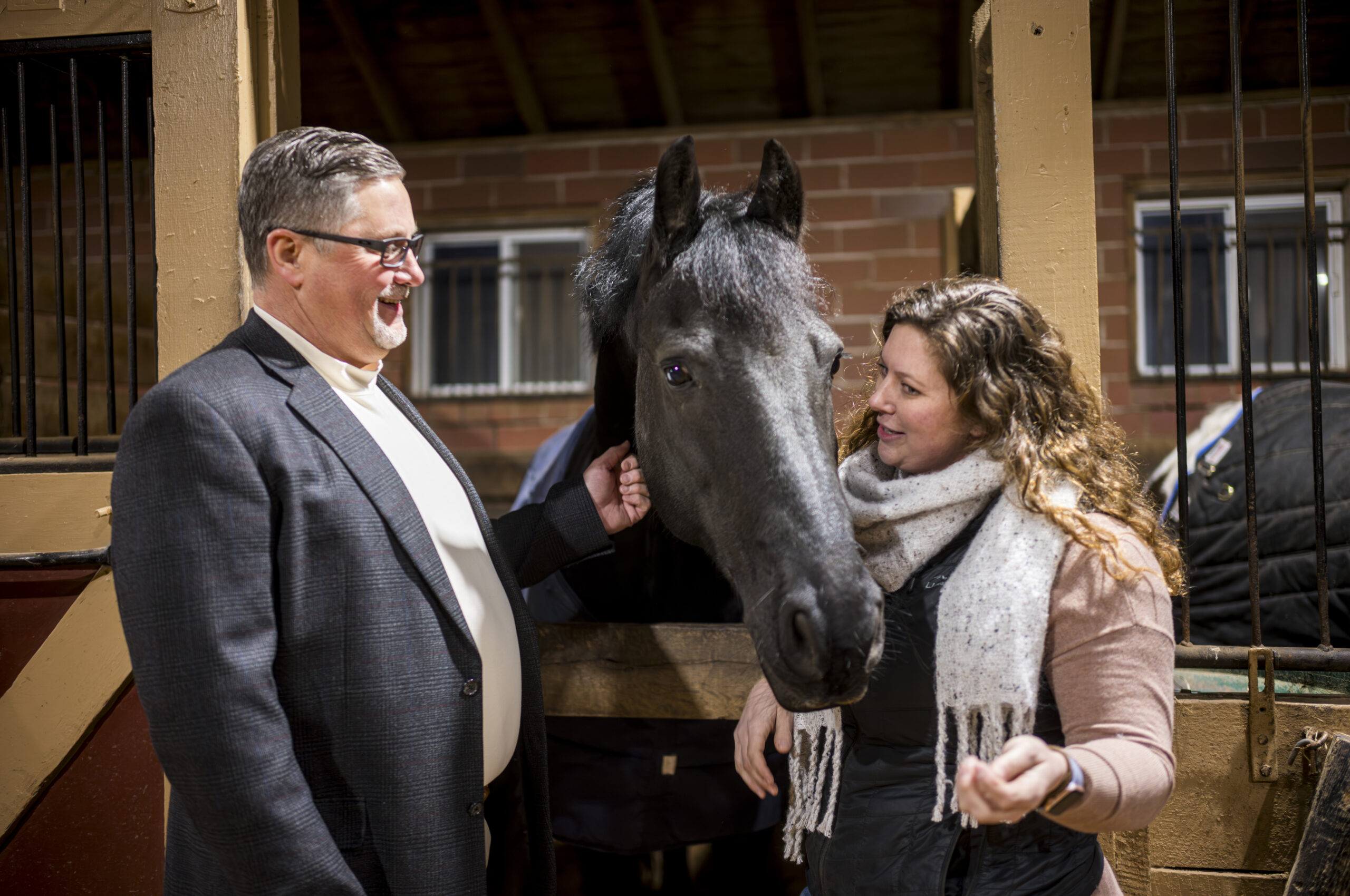 Dr. McCoy and his daughter, Shelby, pet a horse.