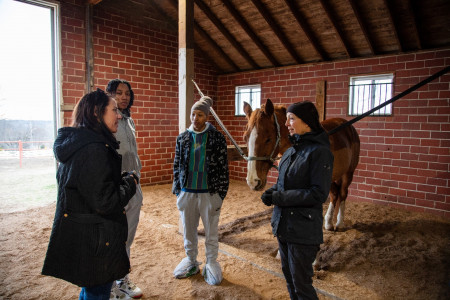 Joan Ranquet talks to a group of students in the equestrian barn.