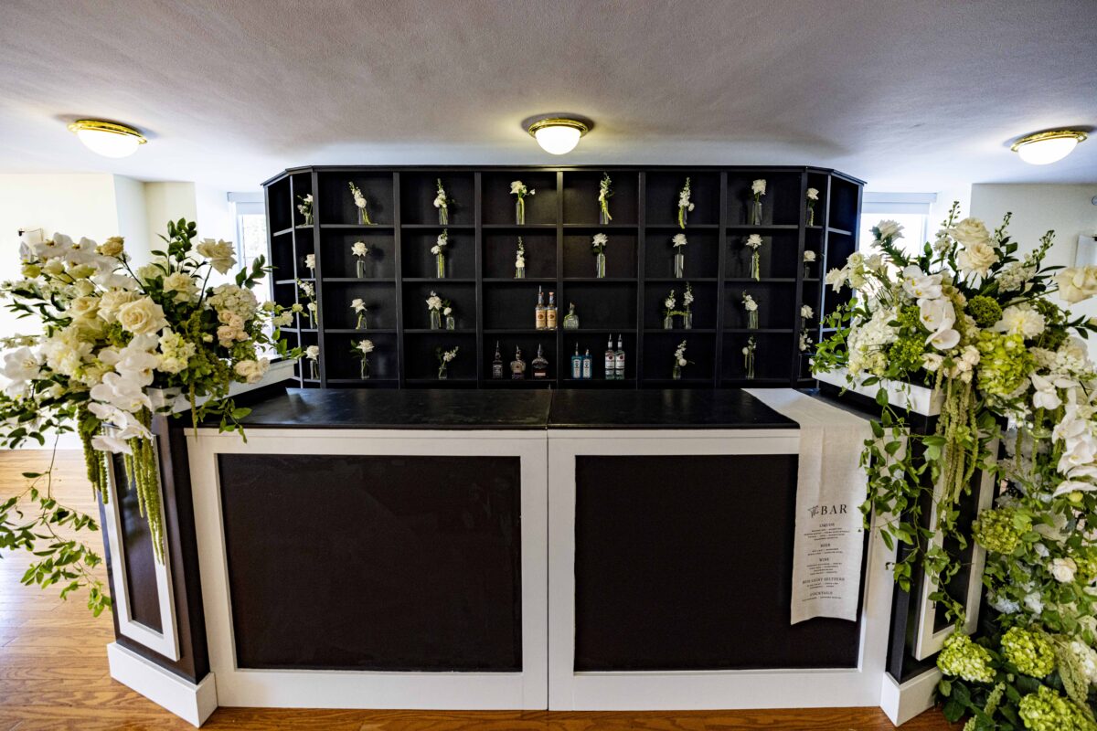 Black and White custom built bar with floral arrangements and bottles