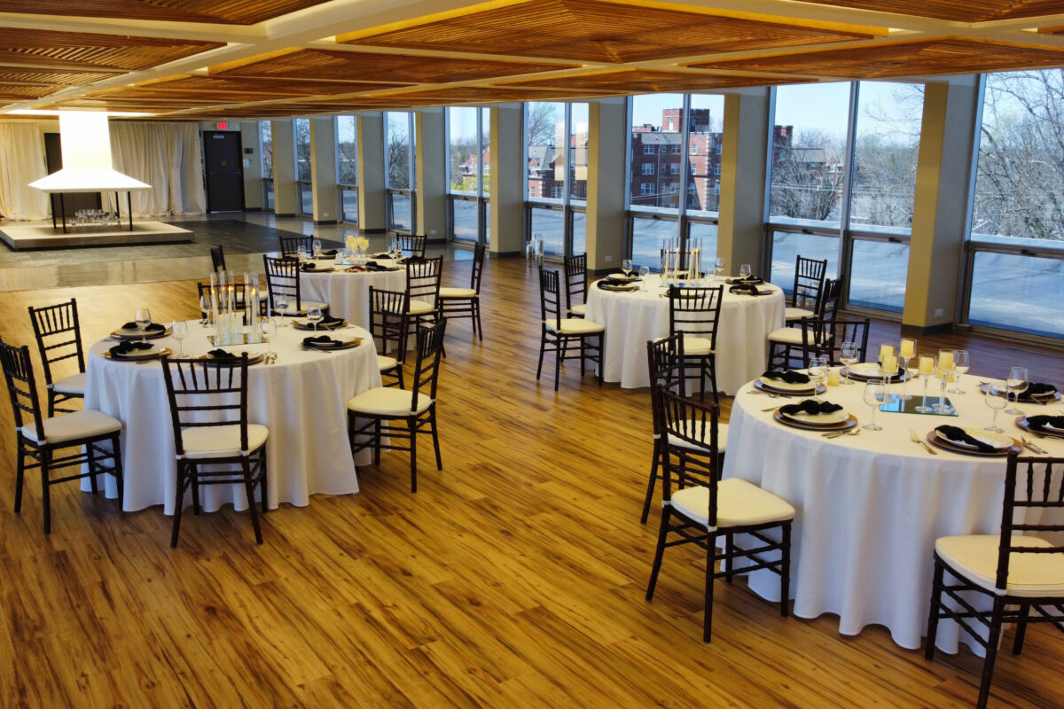 Tables and chairs set up with snow on the roof outside
