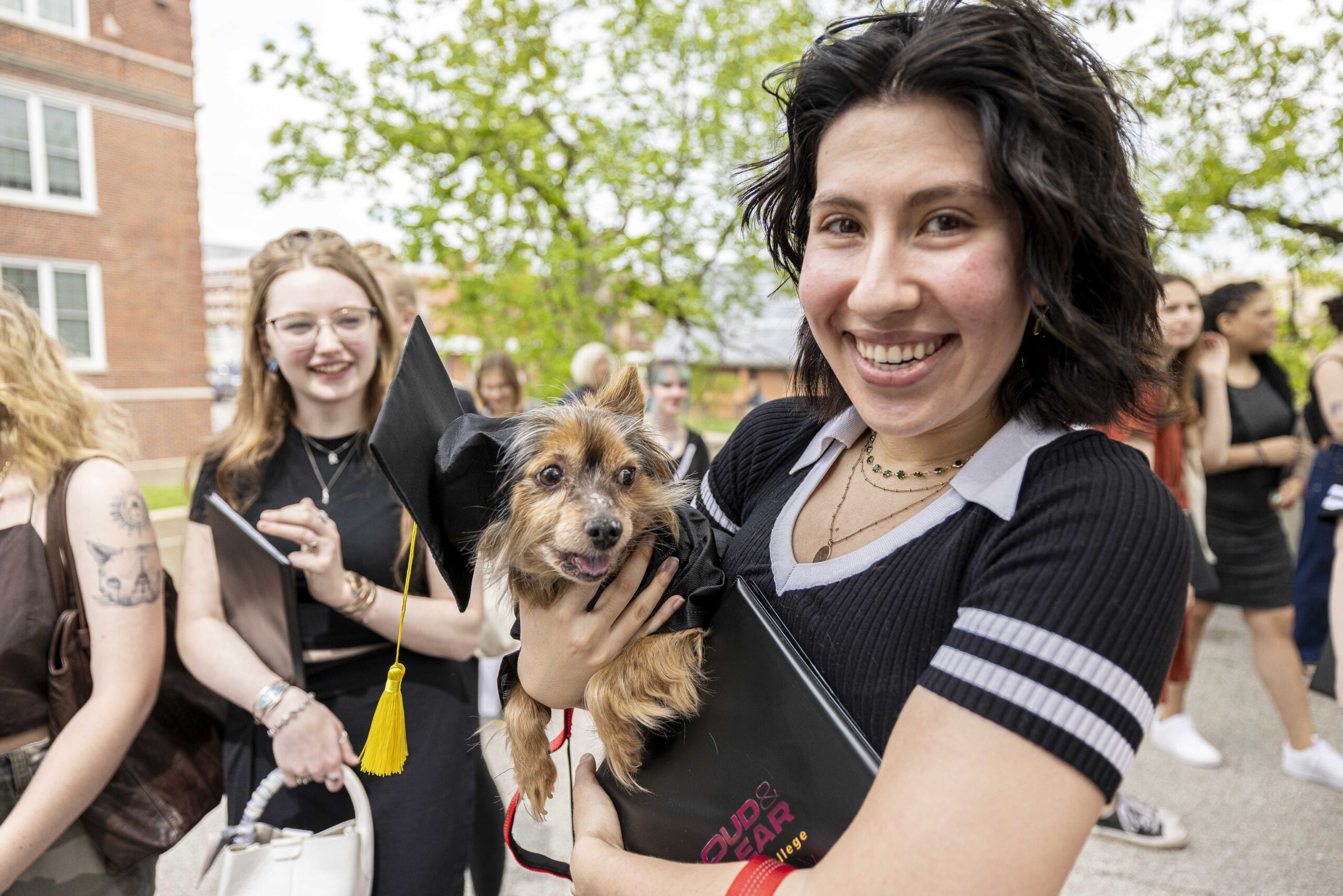 Student holding a small dog at the crossing the bridge ceremony