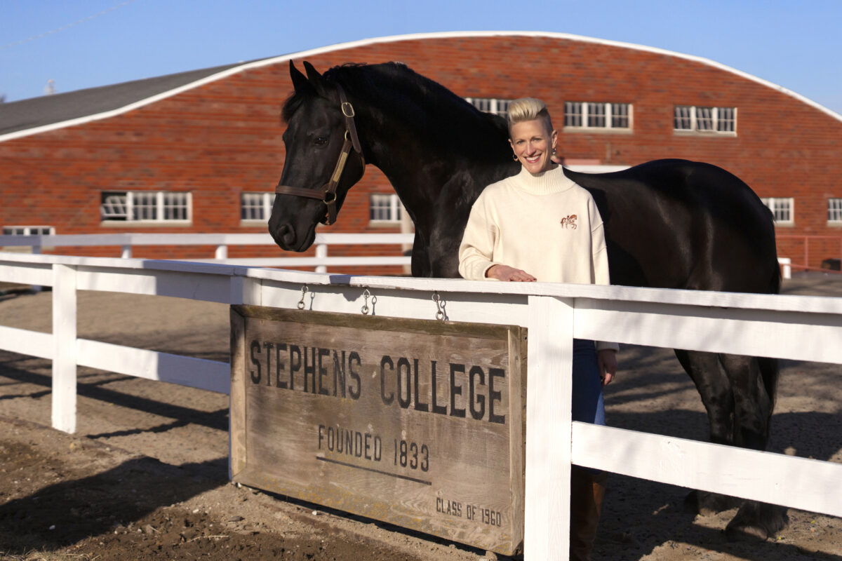 President Shannon B. Lundeen posing with a horse at the Stephens College Equestrian Center